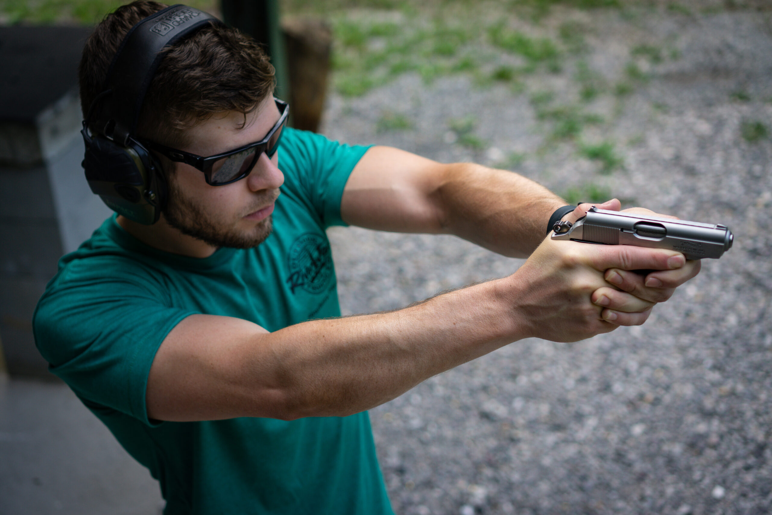 The author firing the Walther PPK pistol at a shooting range as part of the testing done in this review.