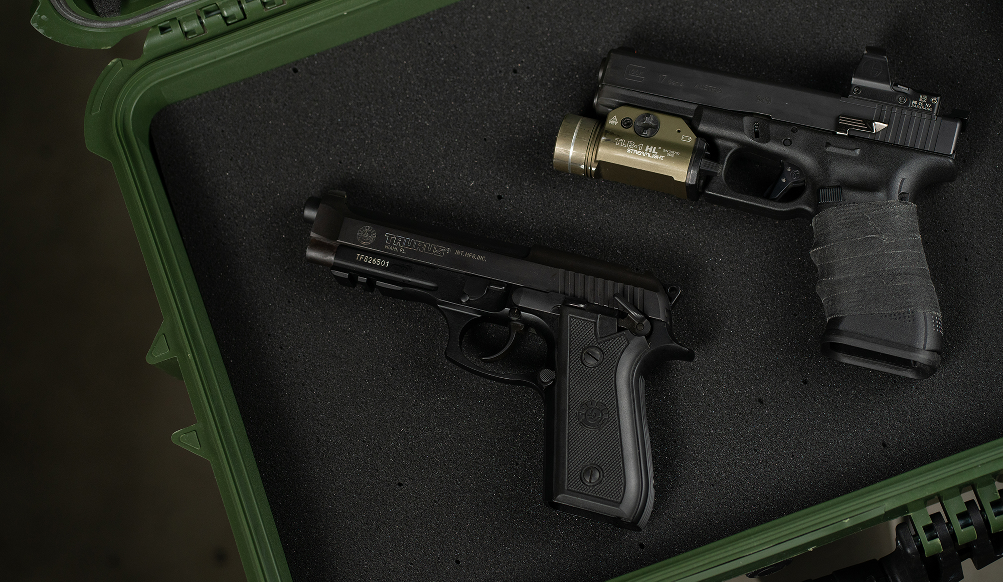 blued pistol next to polymer glock